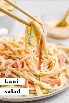 chopsticks holding up noodles and vegetables with the words kani salad above it