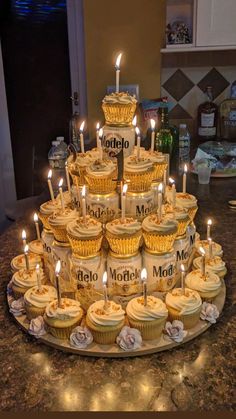 cupcakes are arranged in the shape of a pyramid with candles on each tier