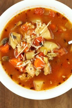 a white bowl filled with soup on top of a wooden table