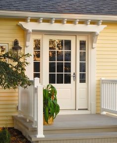 a small yellow house with white trim and front porch