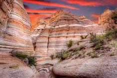 the sun is setting over some very colorful rocks