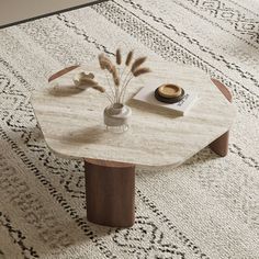 a coffee table with a vase on top and some plants in the middle next to it