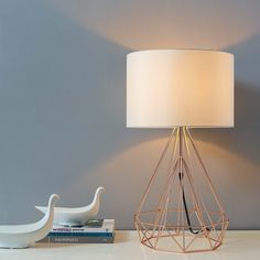 a lamp that is sitting on a table next to a book and some other items