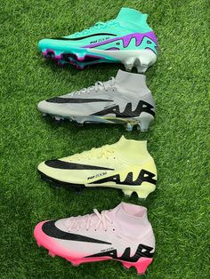 four different colors of soccer shoes on the grass