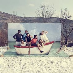 a group of people sitting on top of a boat in the snow