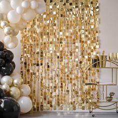 some balloons are in front of a gold and white backdrop with black and white balloons