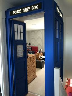 a blue police box sitting in the middle of a living room next to a dresser