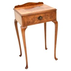 a small wooden table with drawers on one side and an open drawer on the other