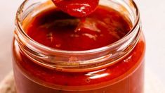 a jar filled with ketchup sitting on top of a table