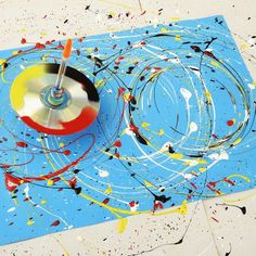 a painting with paint splatters on it and a spinning disc in the middle