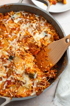 a casserole dish with meat and cheese in it on a white tablecloth