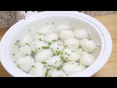 a white bowl filled with food on top of a wooden table