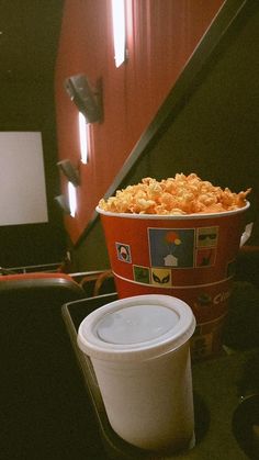 two buckets of popcorn sitting on top of a table