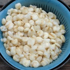 a blue bowl filled with macaroni and cheese on top of a wooden table