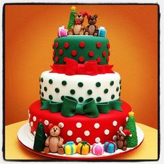 a three tiered cake decorated with teddy bears and christmas decorations on top of it