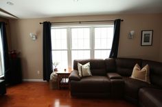 a living room filled with furniture and a flat screen tv on top of a hard wood floor