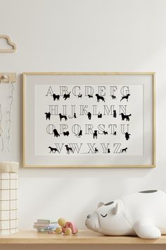 a framed black and white art print on a wall above a wooden shelf with toys