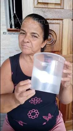 a woman holding a plastic cup with water in it