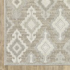 a beige and white rug on top of a wooden floor