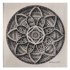 a black and white drawing of a flower in the middle of a circular design on paper