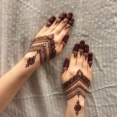 two hands with henna tattoos on them