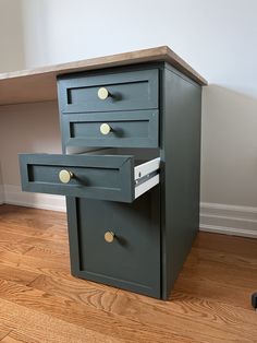 two drawers are stacked on top of each other in front of a desk with a computer mouse