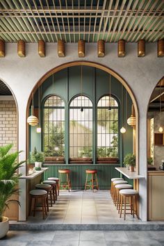 the interior of a restaurant with tables and stools, potted plants, and large arched windows