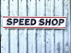 a sign that is on the side of a metal building saying speed shop with graffiti