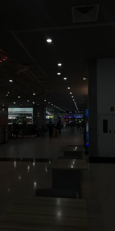 an empty airport terminal at night with people walking around