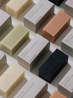 many different types of soaps are arranged on a white surface with black and gray labels