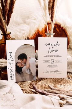 wedding stationery with photos and feathers on the table