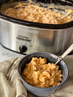 a bowl filled with macaroni and cheese next to a crock pot