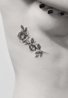 a black and white photo of a woman's stomach with roses on it,