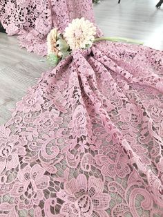 pink crochet lace fabric with flowers on it