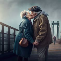 an elderly couple kissing on a bridge