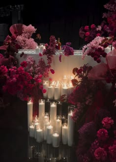 a bunch of candles that are in front of some flowers