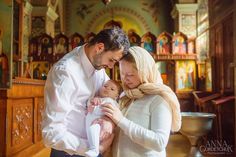 a man and woman holding a baby in a church