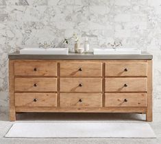 a bathroom vanity with two sinks and wooden drawers