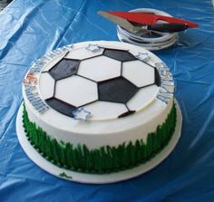 a soccer themed cake on a blue table cloth with scissors and other items around it