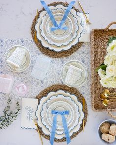 the table is set with blue and white plates, napkins, and silverware