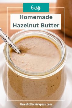 homemade hazelnut butter in a glass jar on a white plate with a metal spoon