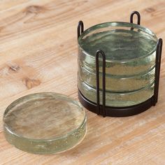 a stack of glass plates sitting on top of a wooden table next to a metal holder