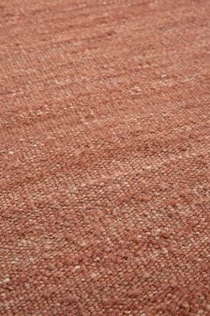 a brown rug with white dots on the top and bottom is shown in close up