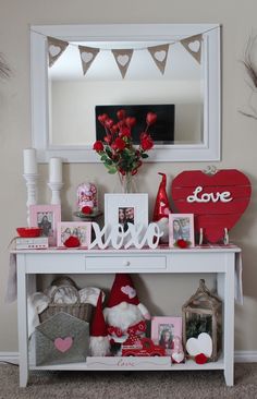 a white table topped with pictures and valentine's day decorations next to a mirror