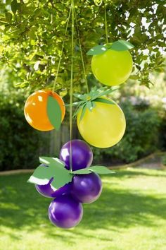 some balloons are hanging from a tree outside