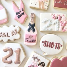 some decorated cookies are arranged on a white surface with pink and gold decorations in the shape of numbers