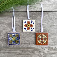 three ceramic ornaments are hanging on the wall