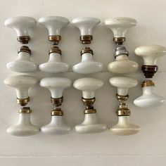 an assortment of white and gold knobs on a wall