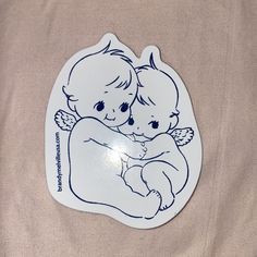 a sticker depicting two babies hugging each other