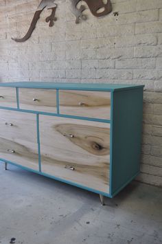 a large wooden dresser sitting next to a brick wall